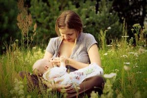 Woman Breastfeeding in field